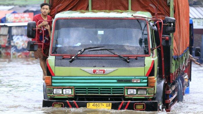 Pengguna jalan melintasi banjir yang kembali menggenangi Jalan Raya Dayeuhkolot, di Kecamatan Dayeuhkolot, Kabupaten Bandung, Jawa Barat, Sabtu (8/3/2025).