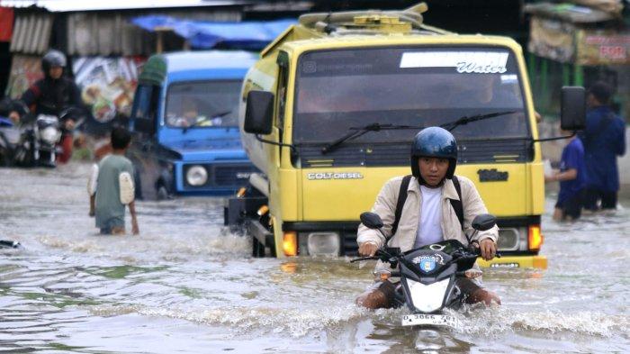 Pengguna jalan melintasi banjir yang kembali menggenangi Jalan Raya Dayeuhkolot, di Kecamatan Dayeuhkolot, Kabupaten Bandung, Jawa Barat, Sabtu (8/3/2025).