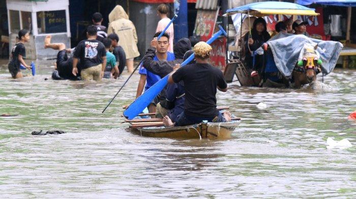 Pengguna jalan melintasi banjir yang kembali menggenangi Jalan Raya Dayeuhkolot, di Kecamatan Dayeuhkolot, Kabupaten Bandung, Jawa Barat, Sabtu (8/3/2025).