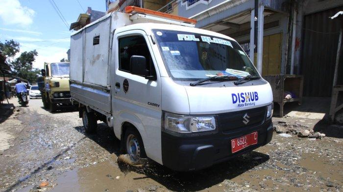 Pengendara motor dan mobil melintasi permukaan jalan rusak yang digenangi air di Jalan Ciroyom Barat, Kelurahan Ciroyom, Kecamatan Andir, Kota Bandung, Jawa Barat, Selasa (11/3/2025).