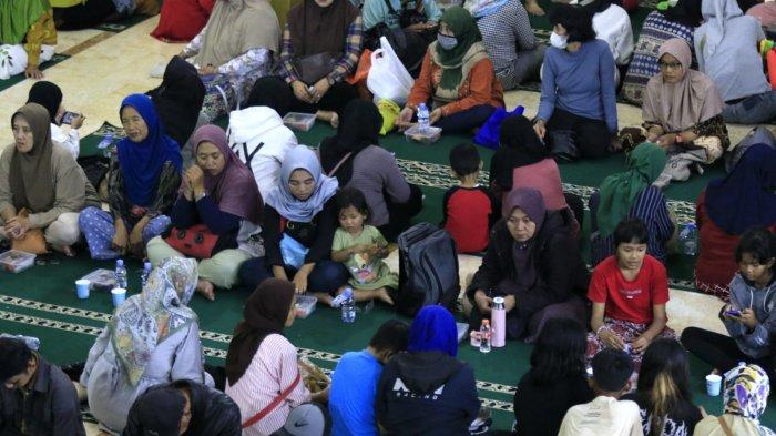 Sejumlah warga menikmati takjil saat mengikuti buka puasa bersama di Masjid Raya Bandung, Alun-Alun Kota Bandung, Jawa Barat, Jumat (14/3/2025).