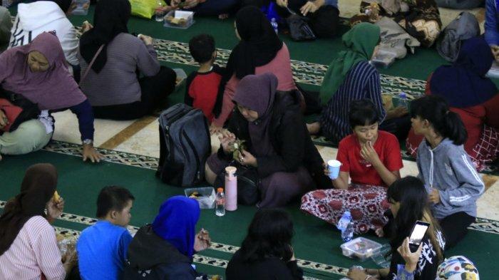Sejumlah warga menikmati takjil saat mengikuti buka puasa bersama di Masjid Raya Bandung, Alun-Alun Kota Bandung, Jawa Barat, Jumat (14/3/2025).