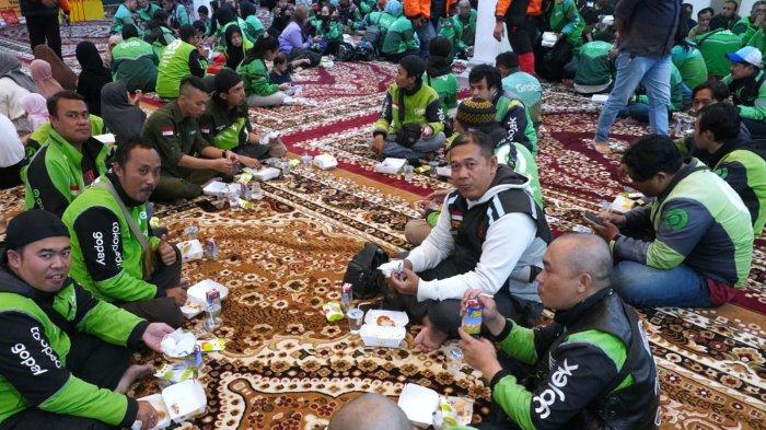 Sejumlah pengemudi ojek online menikmati paket berbuka puasa dari McDonald’s Indonesia pada acara buka puasa bersama dengan mitra dan komunitas pengemudi ojek online, serta anak-anak yatim bertajuk 