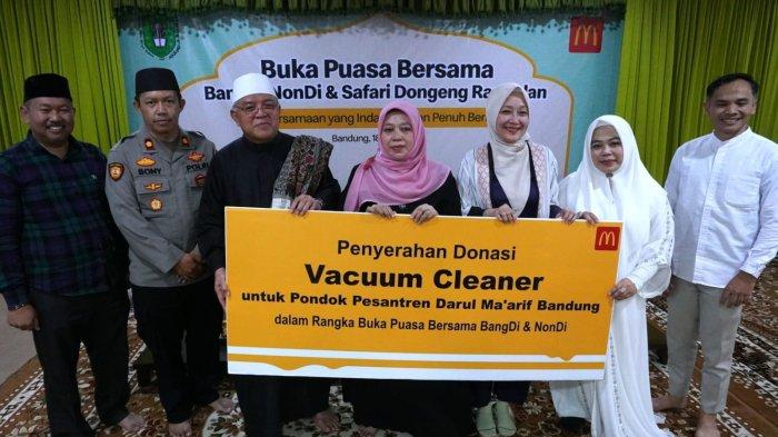 Associate Director of Communication McDonald’s Indonesia, Yulianti Hadena (ketiga kanan), simbolis penyerahan donasi berupa vacuum cleaner untuk Pondok Pesantren Darul Ma’arif diterima oleh Pimpinan Pondok Pesantren Darul Ma'arif, KH Sofyan Yahya pada acara buka puasa bersama dengan mitra dan komunitas pengemudi ojek online, serta anak-anak yatim bertajuk 