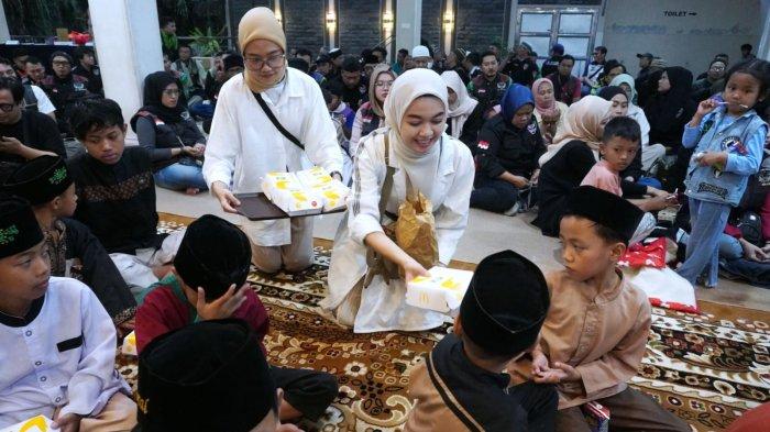 Petugas membagikan paket berbuka puasa dari McDonald’s Indonesia
kepada sejumlah anak yatim pada acara buka puasa bersama dengan mitra dan komunitas pengemudi ojek online, serta anak-anak yatim bertajuk 