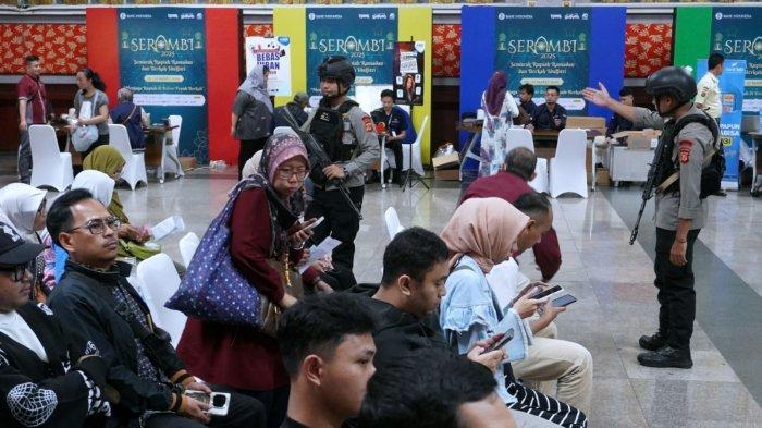 Petugas kepolisian mengatur dengan tertib warga yang akan menukar uang baru pada Semarak Rupiah Ramadan dan Idul Fitri (Serambi) 2025 di Bale Asri Pusdai Jabar, Jalan Diponegoro, Kota Bandung, Jawa Barat, Selasa (18/3/2025).