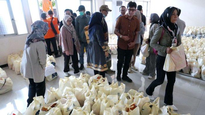 Petugas mendistribuskan paket sembako untuk warga pada acara program Ramadhan Berbagi 1446 H, di Gedung Dirgantara II (Dharma Wanita) PTDI, Kota Bandung, Jawa Barat, Kamis (20/3/2025)