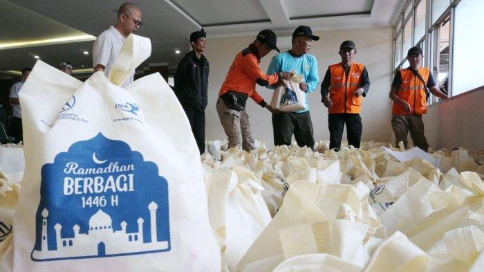 Petugas mendistribuskan paket sembako untuk warga pada acara program Ramadhan Berbagi 1446 H, di Gedung Dirgantara II (Dharma Wanita) PTDI, Kota Bandung, Jawa Barat, Kamis (20/3/2025)