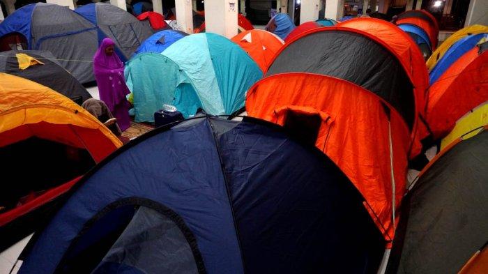 Umat Islam membaca Alquran dan melaksanakan salat di depan tendanya saat mengikuti itikaf di Masjid Habiburrahman PTDI, Jalan Pajajaran, Kota Bandung, Jawa Barat, Jumat (21/3/2025) dinihari.