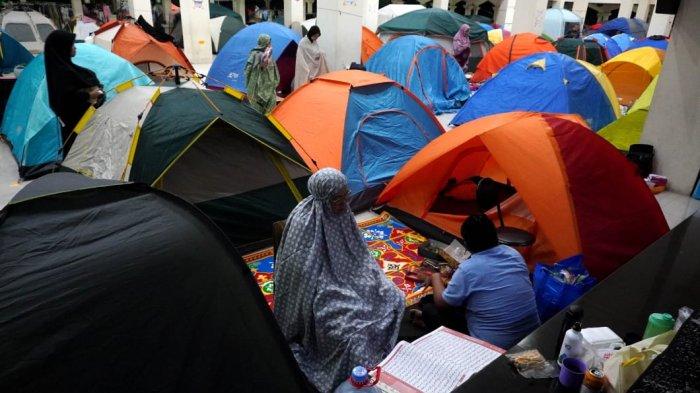 Umat Islam membaca Alquran dan melaksanakan salat di depan tendanya saat mengikuti itikaf di Masjid Habiburrahman PTDI, Jalan Pajajaran, Kota Bandung, Jawa Barat, Jumat (21/3/2025) dinihari.