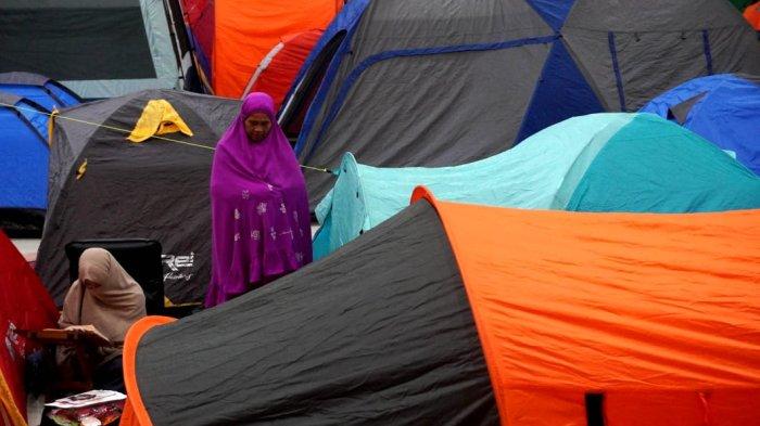 Umat Islam membaca Alquran dan melaksanakan salat di depan tendanya saat mengikuti itikaf di Masjid Habiburrahman PTDI, Jalan Pajajaran, Kota Bandung, Jawa Barat, Jumat (21/3/2025) dinihari.