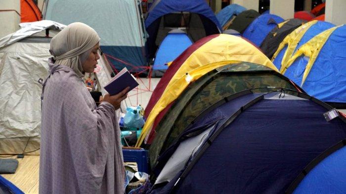Umat Islam membaca Alquran dan melaksanakan salat di depan tendanya saat mengikuti itikaf di Masjid Habiburrahman PTDI, Jalan Pajajaran, Kota Bandung, Jawa Barat, Jumat (21/3/2025) dinihari.