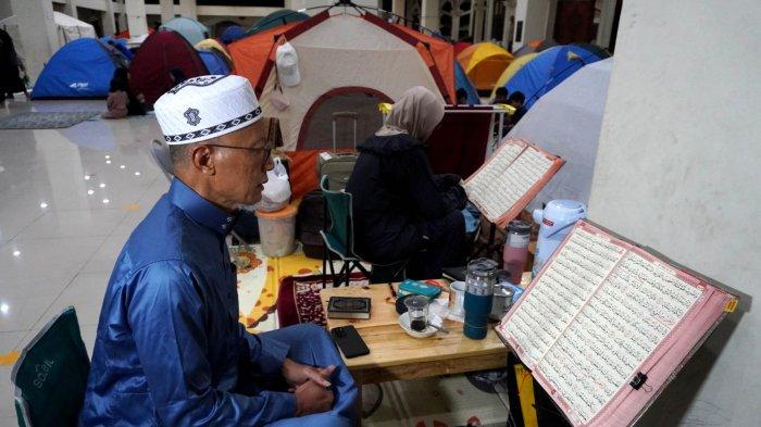 Umat Islam membaca Alquran di depan tendanya saat mengikuti itikaf di Masjid Habiburrahman PTDI, Jalan Pajajaran, Kota Bandung, Jawa Barat, Jumat (21/3/2025) dinihari.