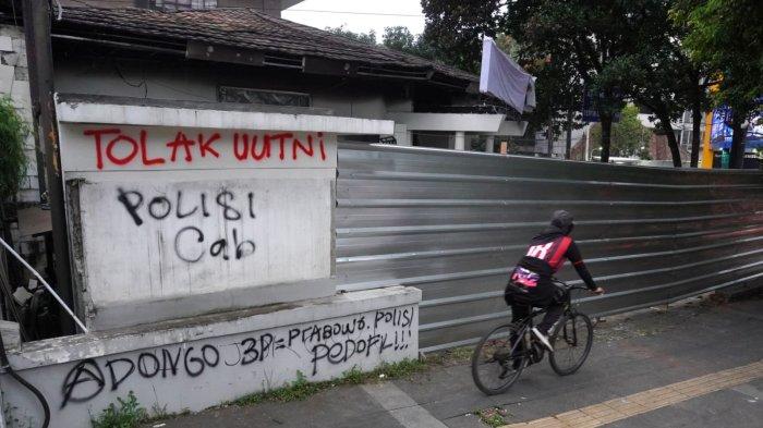 Pesepeda melintas di depan Kantor Hana Bank yang hangus terbakar dan sudah ditutup dengan seng di persimpangan Jalan Ir H Djuanda - Jalan Diponegoro, Dago, Kota Bandung, Jawa Barat, Sabtu (21/3/2025).