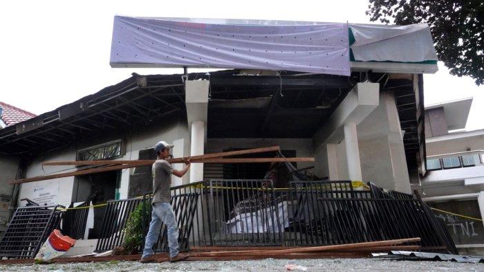 Seorang pekerja menyiapkan kayu untuk menutup Kantor Hana Bank yang hangus terbakar di persimpangan Jalan Ir H Djuanda - Jalan Diponegoro, Dago, Kota Bandung, Jawa Barat, Sabtu (21/3/2025).