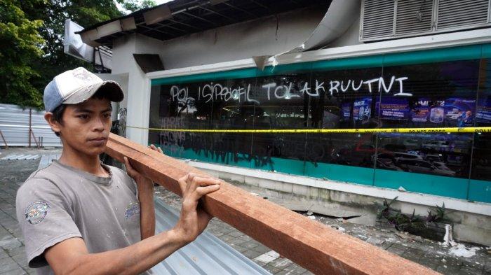 Seorang pekerja menyiapkan kayu untuk menutup Kantor Hana Bank yang hangus terbakar di persimpangan Jalan Ir H Djuanda - Jalan Diponegoro, Dago, Kota Bandung, Jawa Barat, Sabtu (21/3/2025).