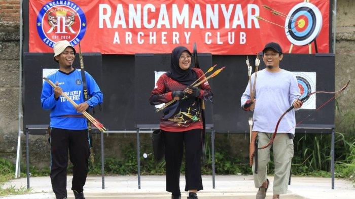 Pelatih dan pembina Rancamanyar Archery Club (RAC), Ustadz Fadhil Al Makky bersama atlet panahan Kabupaten Bandung, Sindy Oktaviani dan warga berlatih panahan di Rancamanyar Archery Club (RAC), Rancamanyar Regency 1, Desa Rancamanyar, Kecamatan Baleendah, Kabupaten Bandung, Jawa Barat, Senin (24/3/2025).