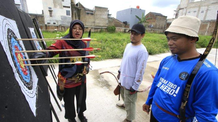 Pelatih dan pembina Rancamanyar Archery Club (RAC), Ustadz Fadhil Al Makky bersama atlet panahan Kabupaten Bandung, Sindy Oktaviani dan warga berlatih panahan di Rancamanyar Archery Club (RAC), Rancamanyar Regency 1, Desa Rancamanyar, Kecamatan Baleendah, Kabupaten Bandung, Jawa Barat, Senin (24/3/2025).