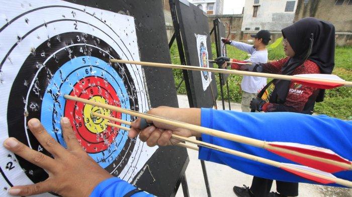 Pelatih dan pembina Rancamanyar Archery Club (RAC), Ustadz Fadhil Al Makky bersama atlet panahan Kabupaten Bandung, Sindy Oktaviani dan warga berlatih panahan di Rancamanyar Archery Club (RAC), Rancamanyar Regency 1, Desa Rancamanyar, Kecamatan Baleendah, Kabupaten Bandung, Jawa Barat, Senin (24/3/2025).