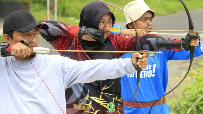 Pelatih dan pembina Rancamanyar Archery Club (RAC), Ustadz Fadhil Al Makky bersama atlet panahan Kabupaten Bandung, Sindy Oktaviani dan warga berlatih panahan di Rancamanyar Archery Club (RAC), Rancamanyar Regency 1, Desa Rancamanyar, Kecamatan Baleendah, Kabupaten Bandung, Jawa Barat, Senin (24/3/2025).