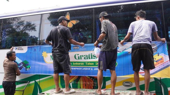 Sejumlah pekerja memasang stiker Mudik Gratis Bersama Pemprov Jabar dan Jasa Raharja pada bus pariwisata di Pool Bus Pariwisata Suryaputra (SPA), Jalan Leuwipanjang, Kota Bandung, Jawa Barat, Selasa (25/3/2025).