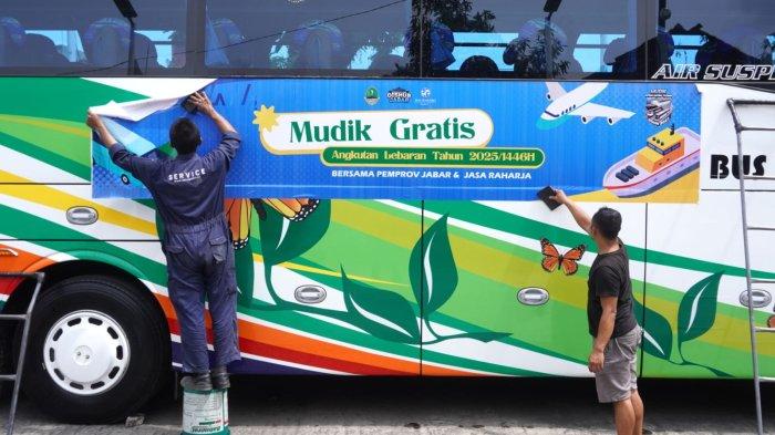 Sejumlah pekerja memasang stiker Mudik Gratis Bersama Pemprov Jabar dan Jasa Raharja pada bus pariwisata di Pool Bus Pariwisata Suryaputra (SPA), Jalan Leuwipanjang, Kota Bandung, Jawa Barat, Selasa (25/3/2025).