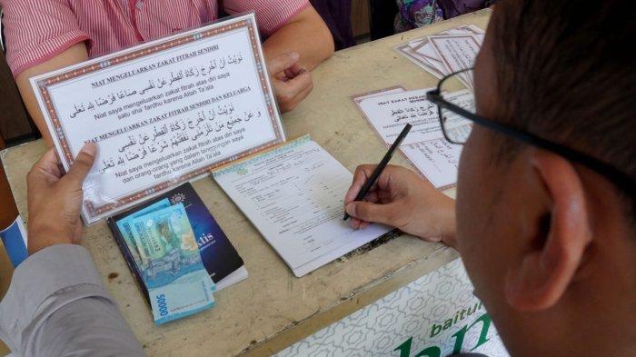 Warga membayar zakat fitrah di Counter Penerimaan Zakat Maal, Fitrah, Infaq, Shadaqah, dan Wakaf Alquran, di Masjid Pusdai Jabar, Jalan Diponegoro, Kota Bandung, Jawa Barat, Rabu (26/3/2025).