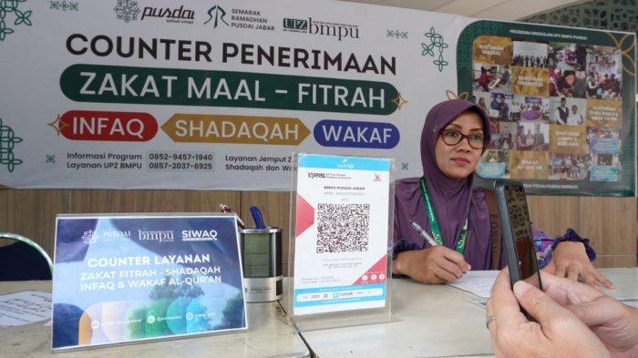 Warga membayar zakat fitrah di Counter Penerimaan Zakat Maal, Fitrah, Infaq, Shadaqah, dan Wakaf Alquran, di Masjid Pusdai Jabar, Jalan Diponegoro, Kota Bandung, Jawa Barat, Rabu (26/3/2025).