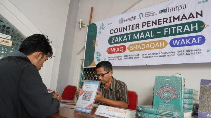 Warga membayar zakat fitrah di Counter Penerimaan Zakat Maal, Fitrah, Infaq, Shadaqah, dan Wakaf Alquran, di Masjid Pusdai Jabar, Jalan Diponegoro, Kota Bandung, Jawa Barat, Rabu (26/3/2025).