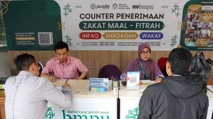Warga membayar zakat fitrah di Counter Penerimaan Zakat Maal, Fitrah, Infaq, Shadaqah, dan Wakaf Alquran, di Masjid Pusdai Jabar, Jalan Diponegoro, Kota Bandung, Jawa Barat, Rabu (26/3/2025).
