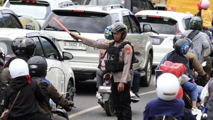 Polisi mengatur lalu lintas kendaraan saat kondisi padat di Jalan Nagreg, Kabupaten Bandung, Jawa Barat, Sabtu (29/3/2025).