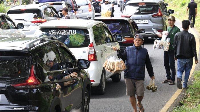 Pedagang menawarkan makanan dan minuman kepada para pemudik saat lalu lintas padat dan macet di Jalan Nagreg, Kabupaten Bandung, Jawa Barat, Sabtu (29/3/2025).