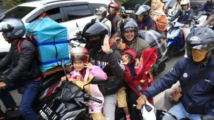 Pemudik bermotor membawa tiga anak kecil melintas di Jalan Nagreg, Kabupaten Bandung, Jawa Barat, Sabtu (29/3/2025).