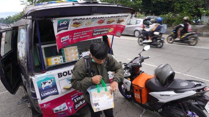 Seorang pemudik membeli oleh-oleh Bolu Lembang di kawasan Rancaekek Jalan Raya Garut - Bandung, Rancaekek, Kabupaten Bandung, Jawa Barat, Sabtu (29/3/2025).