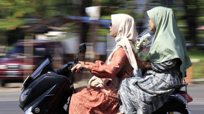 Warga membawa bunga akan berziarah kubur pada Idul Fitri 1446 H ke Tempat Pemakaman Umum (TPU) Legok Ciseureuh, Kelurahan Mekarwangi, Kecamatan Bojongloa Kidul, Kota Bandung, Jawa Barat, Senin (31/3/2025).