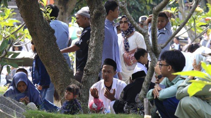 Sejumlah warga berziarah ke makam keluarga pada Idul Fitri 1446 H, di Tempat Pemakaman Umum (TPU) Legok Ciseureuh, Kelurahan Mekarwangi, Kecamatan Bojongloa Kidul, Kota Bandung, Jawa Barat, Senin (31/3/2025).
