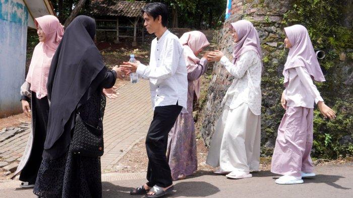 Warga bersalaman saat bersilaturahmi Lebaran, di Kampung Bandrek, Desa Sukamerang, Kecamatan Kersamanah, Kabupaten Garut, Jawa Barat, Selasa (1/4/2025).