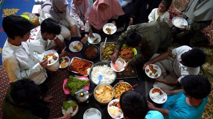 Satu keluarga makan bersama dengan menu masakan khas Lebaran, di Kampung Bandrek, Desa Sukamerang, Kecamatan Kersamanah, Kabupaten Garut, Jawa Barat, Selasa (1/4/2025).