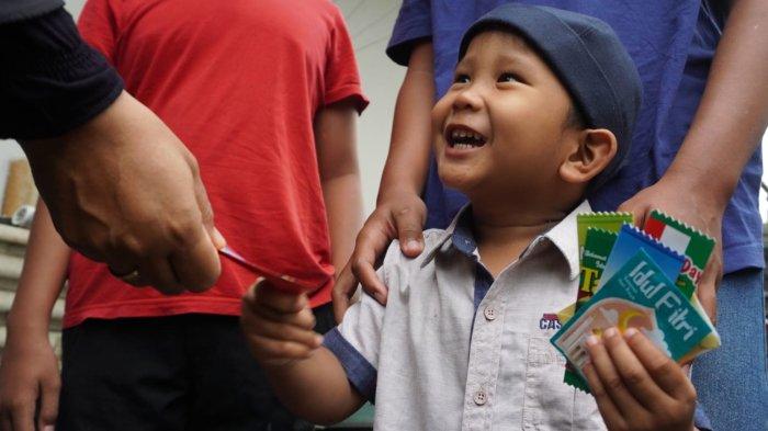 Anak kecil menerima uang hadiah Lebaran, di Kampung Bandrek, Desa Sukamerang, Kecamatan Kersamanah, Kabupaten Garut, Jawa Barat, Selasa (1/4/2025).