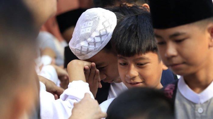 Murid menyalami satu persatu guru dalam acara halalbihalal Lebaran 2025 di SDN 148 Cibaduyut, Jalan Cibaduyut Raya, Kota Bandung, Jawa Barat, Rabu (9/4/2025).