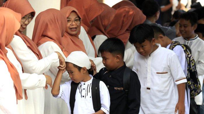 Murid menyalami satu persatu guru dalam acara halalbihalal Lebaran 2025 di SDN 148 Cibaduyut, Jalan Cibaduyut Raya, Kota Bandung, Jawa Barat, Rabu (9/4/2025).