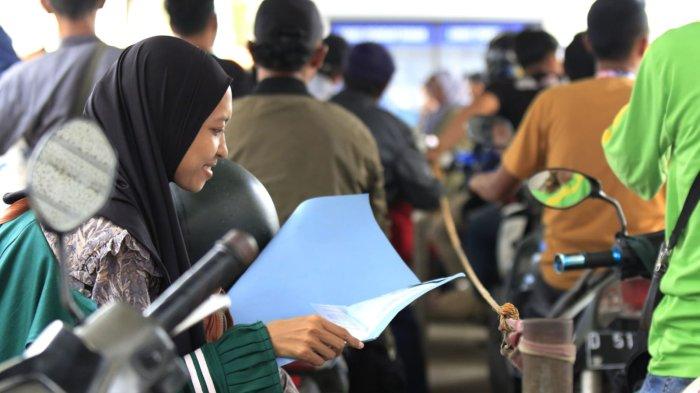 Warga yang akan membayar pajak kendaraan mempersiapkan berkas sambil mengantre untuk cek fisik kendaraan roda duanya di halaman Kantor Samsat Soreang, Jalan Raya Gading Tutuka, Cingcin, Kabupaten Bandung, Jawa Barat, Rabu (9/4/2025).