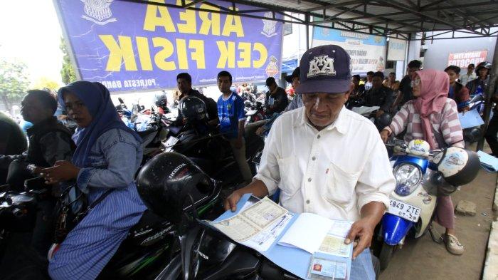 Warga yang akan membayar pajak kendaraan bermotor (PKB) mempersiapkan berkas sambil mengantre untuk cek fisik kendaraan roda duanya di halaman Kantor Samsat Soreang, Jalan Raya Gading Tutuka, Cingcin, Kabupaten Bandung, Jawa Barat, Rabu (9/4/2025).