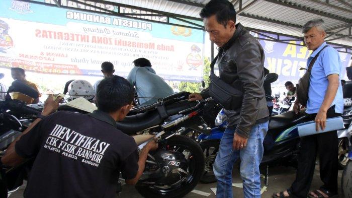 Warga yang akan membayar pajak kendaraan bermotor (PKB) melakukan cek fisik kendaraan roda duanya di halaman Kantor Samsat Soreang, Jalan Raya Gading Tutuka, Cingcin, Kabupaten Bandung, Jawa Barat, Rabu (9/4/2025).