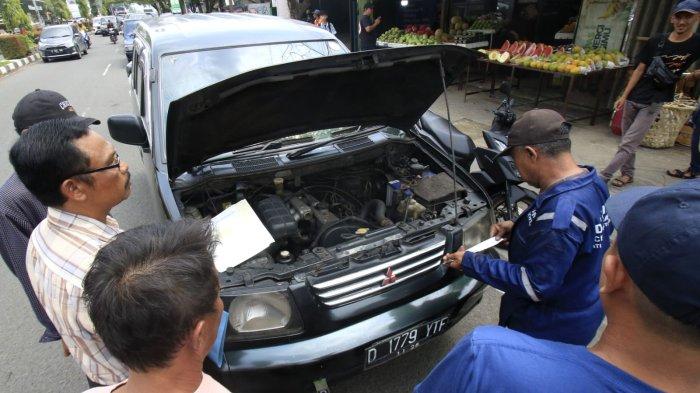 Warga yang akan membayar pajak kendaraan bermotor (PKB) melakukan cek fisik kendaraan roda empatnya di depan Kantor Samsat Soreang, Jalan Raya Gading Tutuka, Cingcin, Kabupaten Bandung, Jawa Barat, Rabu (9/4/2025).