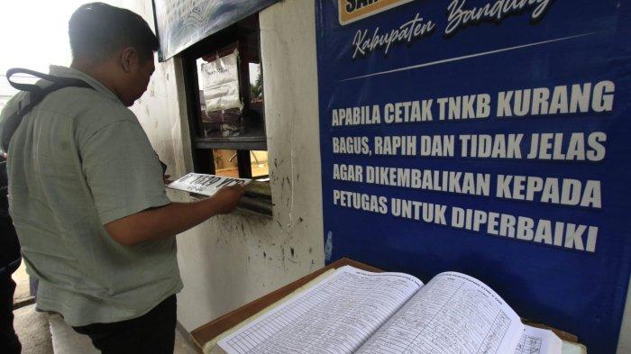 Warga yang setelah melakukan pembayaran pajak kendaraan bermotor (PKB) mengambil plat nomor di ruangan bagian belakang Kantor Samsat Soreang, Jalan Raya Gading Tutuka, Cingcin, Kabupaten Bandung, Jawa Barat, Rabu (9/4/2025).