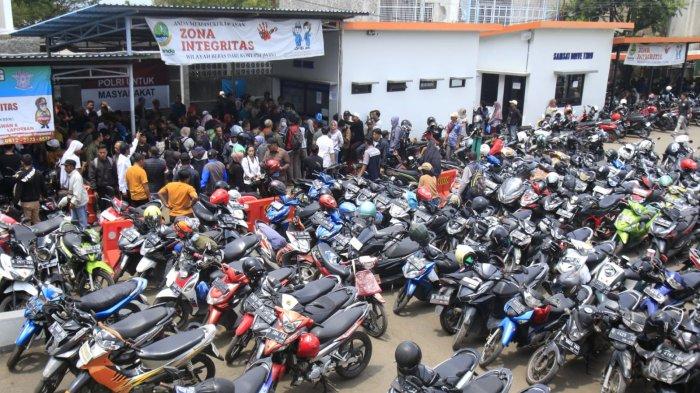 Warga yang akan membayar pajak kendaraan bermotor (PKB) mempersiapkan berkas sambil mengantre untuk cek fisik kendaraan roda duanya di halaman Kantor Samsat Soreang, Jalan Raya Gading Tutuka, Cingcin, Kabupaten Bandung, Jawa Barat, Rabu (9/4/2025).