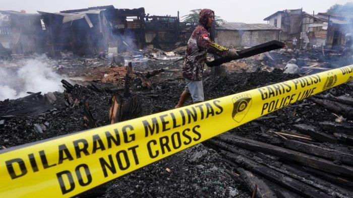 Warga mengumpulkan kayu yang hangus terbakar di lokasi kebakaran, di Jalan Terusan Pasirkoja, Kelurahan Sukahaji, Kecamatan Babakan Ciparay, Kota Bandung, Jawa Barat, Kamis (10/4/2025).