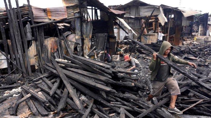 Warga mengumpulkan kayu yang hangus terbakar di lokasi kebakaran, di Jalan Terusan Pasirkoja, Kelurahan Sukahaji, Kecamatan Babakan Ciparay, Kota Bandung, Jawa Barat, Kamis (10/4/2025).