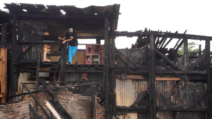 Pemilik kios kayu membuang sisa material bangunan yang terbakar di lokasi kebakaran, di Jalan Terusan Pasirkoja, Kelurahan Sukahaji, Kecamatan Babakan Ciparay, Kota Bandung, Jawa Barat, Kamis (10/4/2025).
